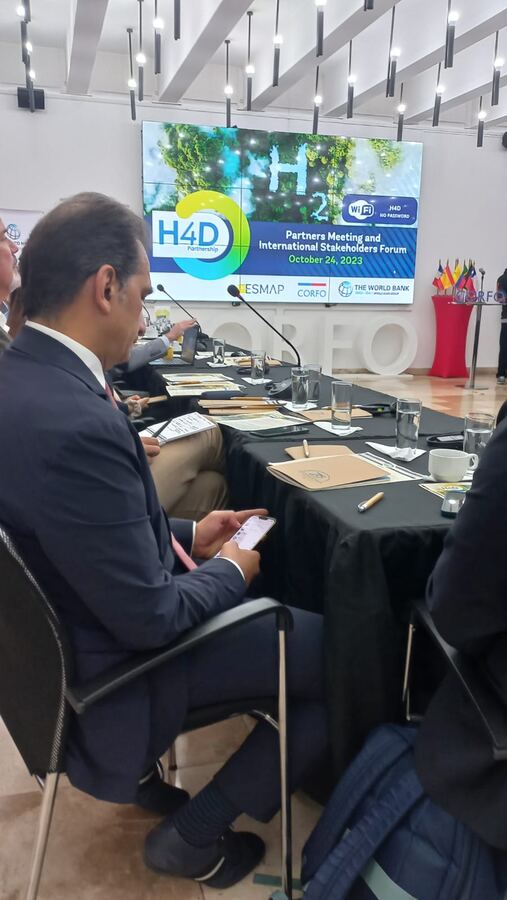 Mesa técnica internacional con delegados usando micrófonos y sistema de interpretación